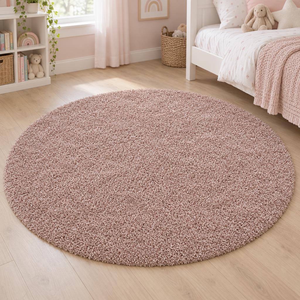 Rond hoogpolig vloerkleed Shaggy Ritual Roze in zacht oudroze, naast het bed – sfeerimpressie in de kinderkamer