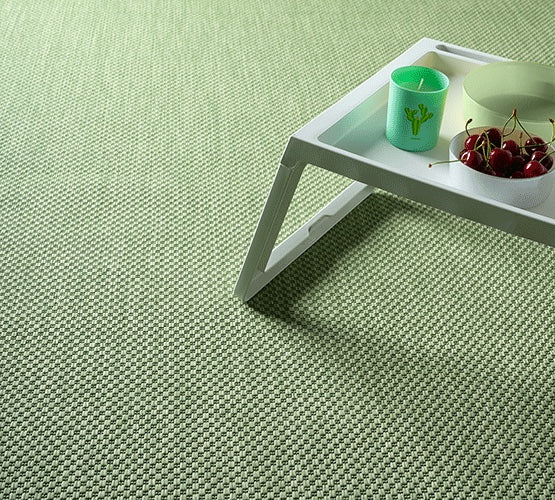 Vloerkleed Maestro Groen – Weerbestendige Sisallook voor Binnen en Buiten – hoek van het kleed op een houten terras