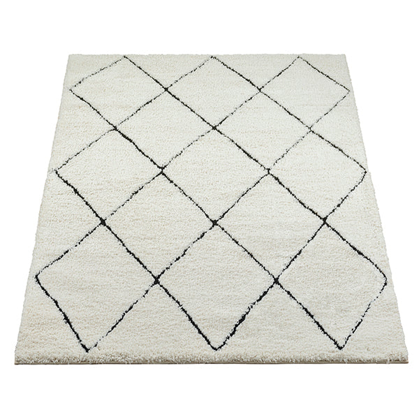 Vloerkleed Ideal Shaggy Wit-Zwart – Hoogpolige Shaggy van 30 mm – opgerolde hoek met zicht op de jute rugzijde