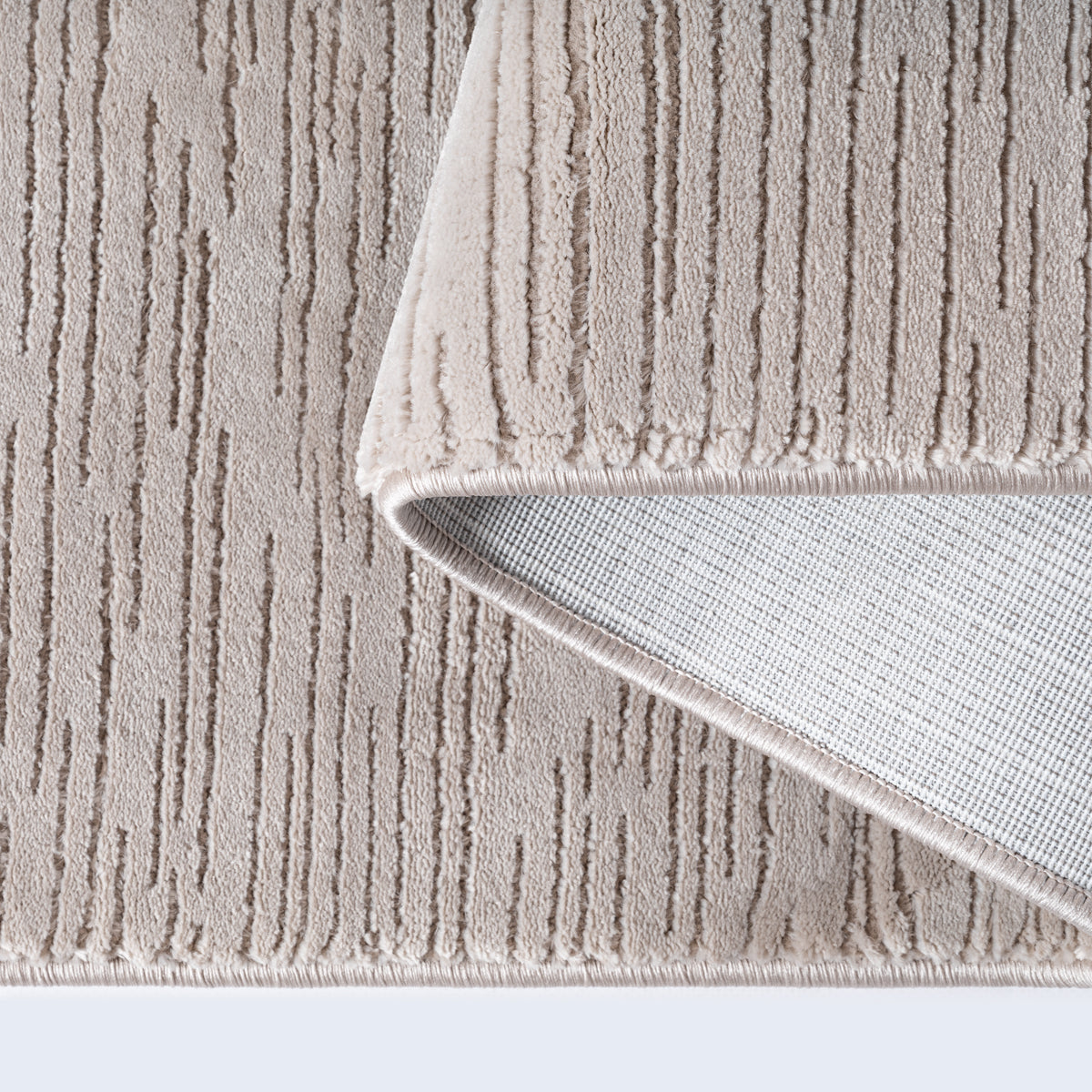 Vloerkleed Sign 1984 Beige – Zandtint met Geweven Reliëfvlakken – sfeerimpressie in de woonkamer