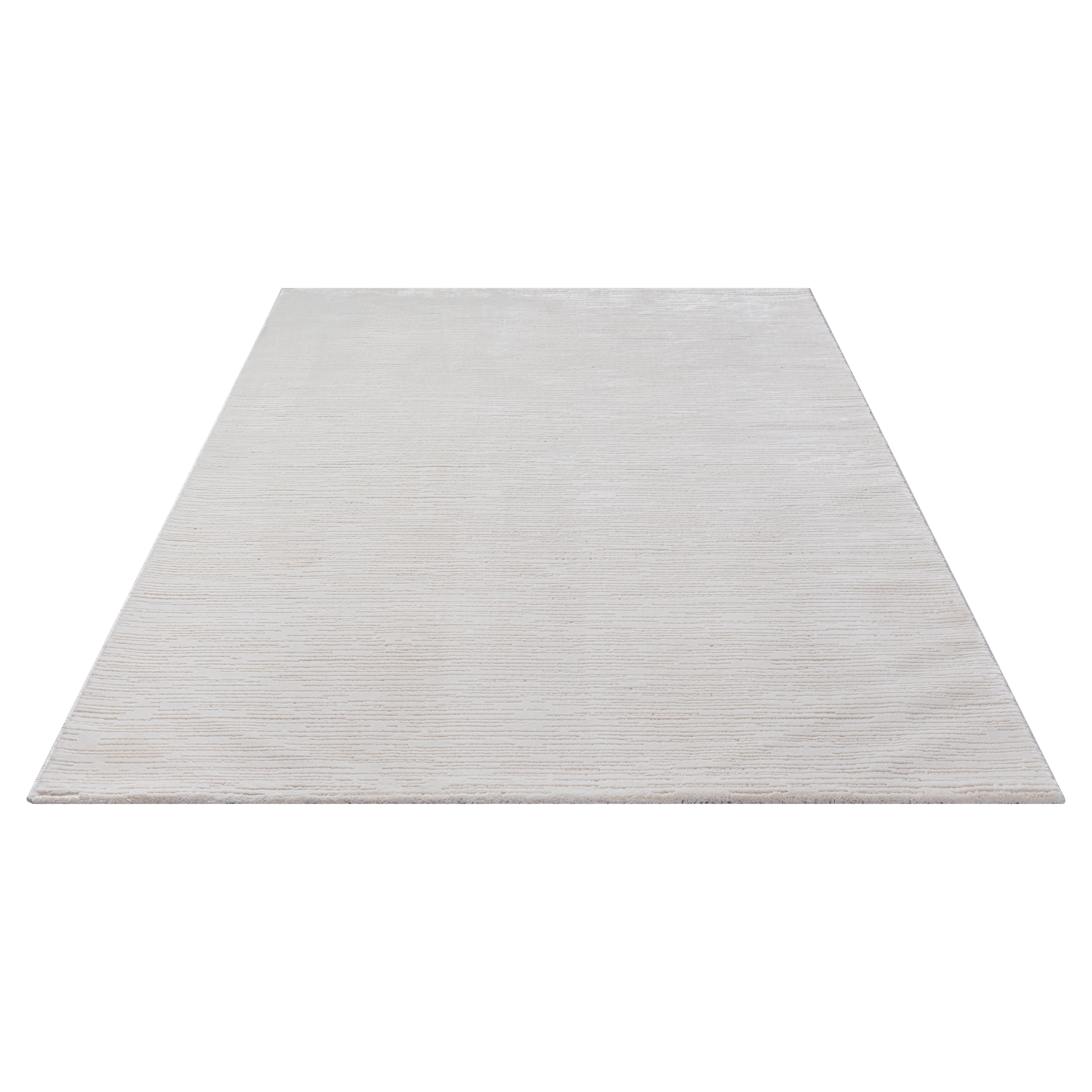 Vloerkleed Sign 1984 Crème – Lichte Basis met Zachte Reliëfpool – opgerolde hoek op houten vloer