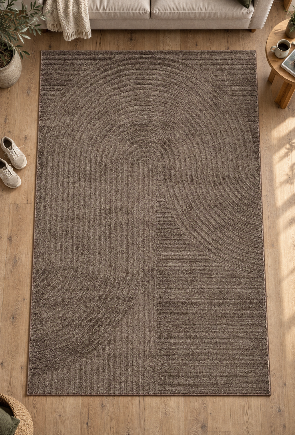 Vloerkleed Elio 2251 Bruin met gebogen weefpatroon op een houten vloer bij een bank