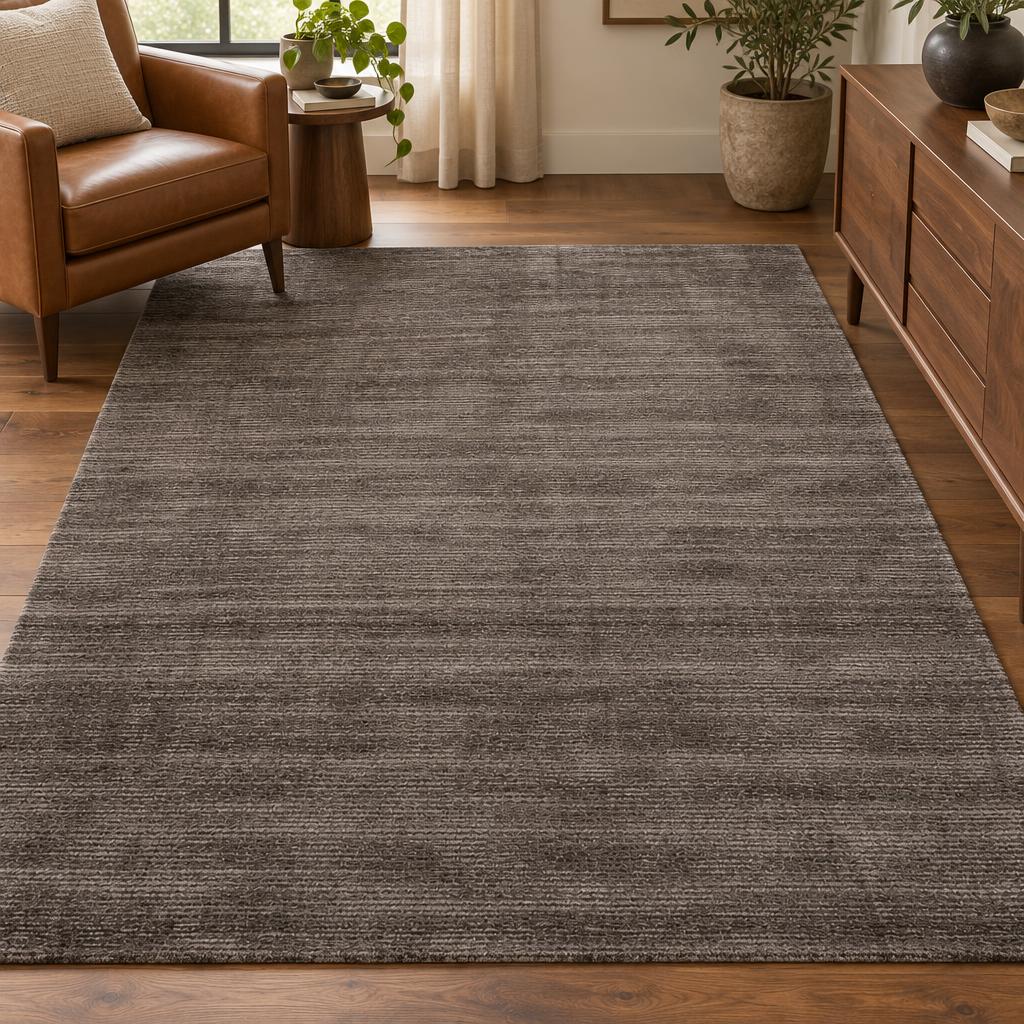 Handgetuft vloerkleed Arte Taupe in warm grijsbruin met zachte glans – sfeerimpressie in de woonkamer