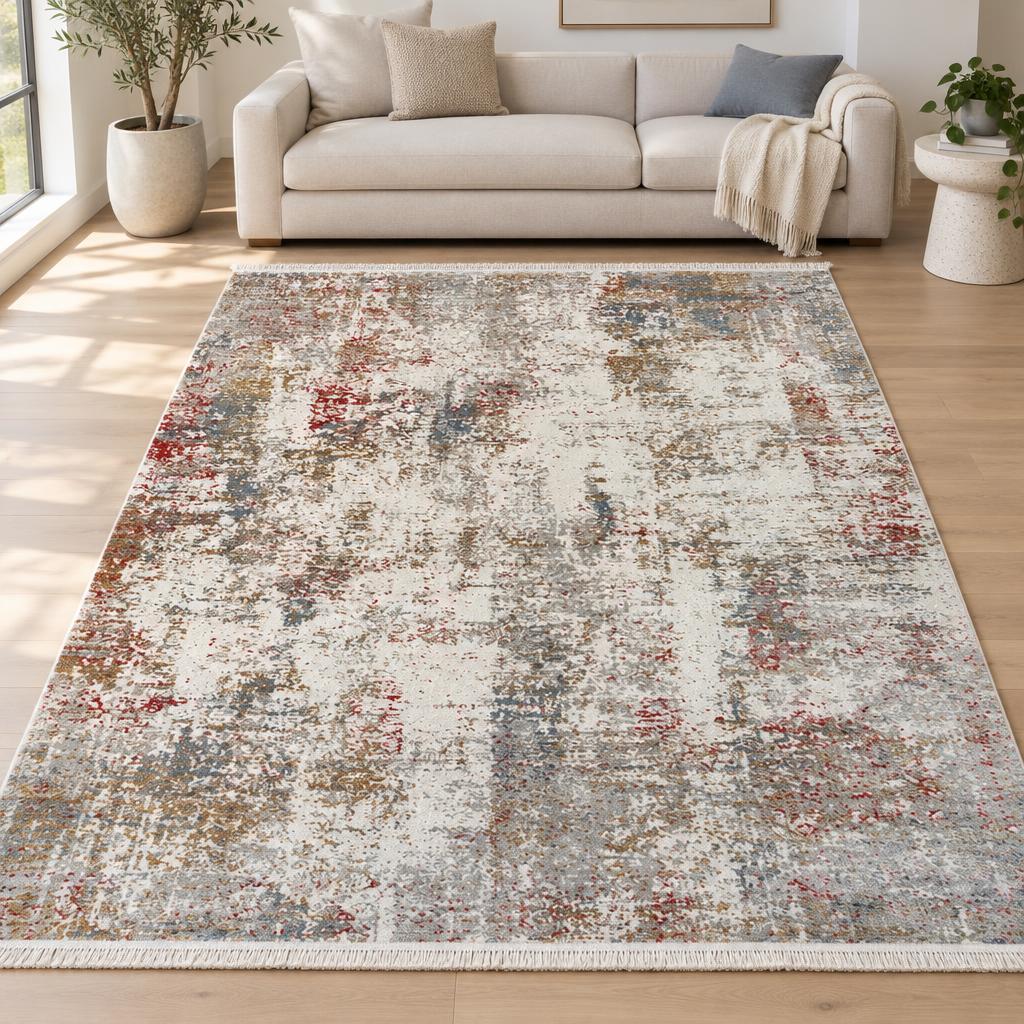 Vloerkleed Fabia Multicolour met abstracte vlekken in rood, blauw, oker en grijs op ivoor voor een lichte bank – sfeerimpressie in de woonkamer