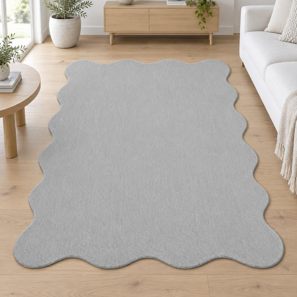 Vloerkleed Loft Shape 42 Grijs met golvende rand tussen een witte bank en salontafel – sfeerimpressie in de woonkamer