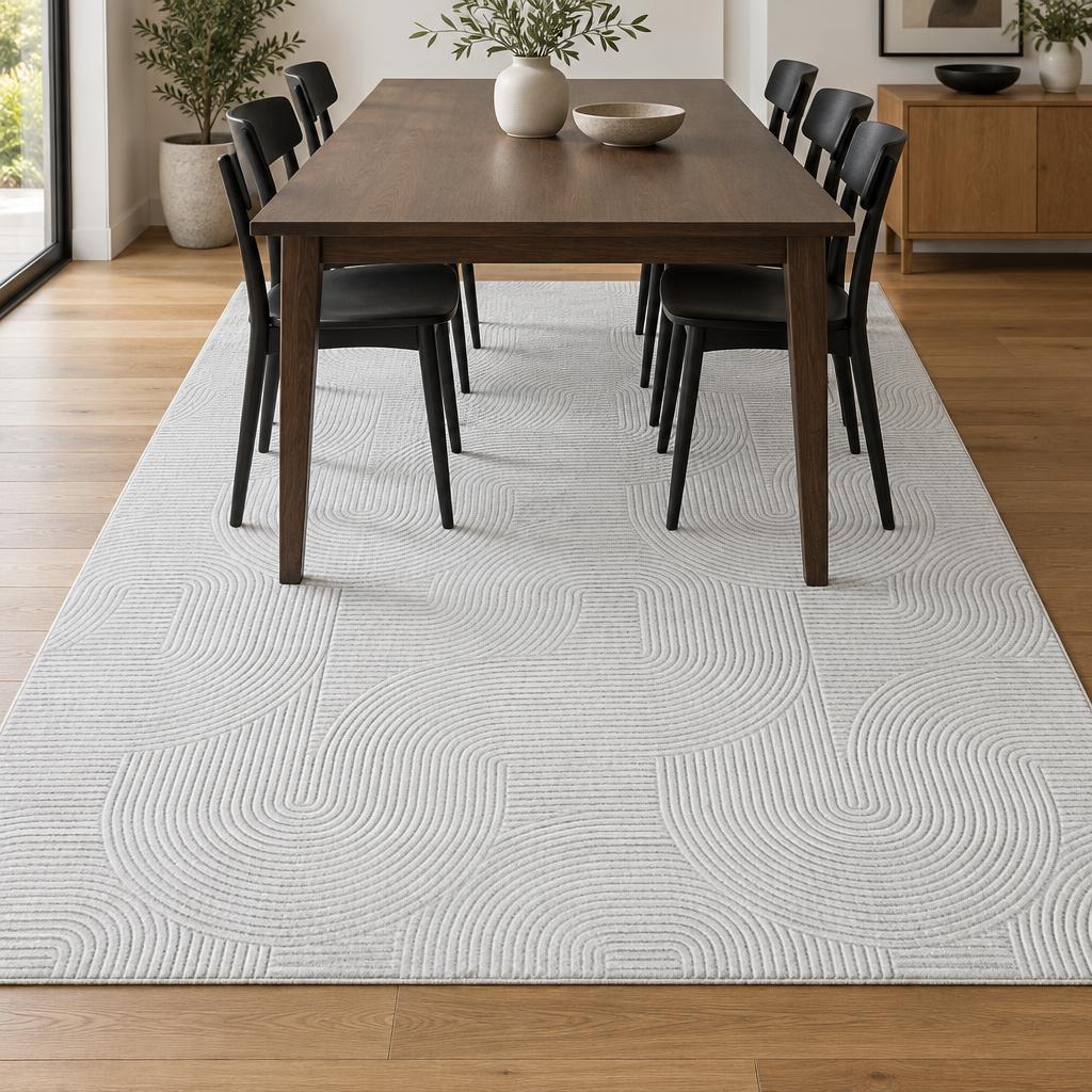 Vloerkleed Stilo 390 Gebroken Wit met boog- en lijnenreliëf onder de eettafel – sfeerimpressie in de eetkamer