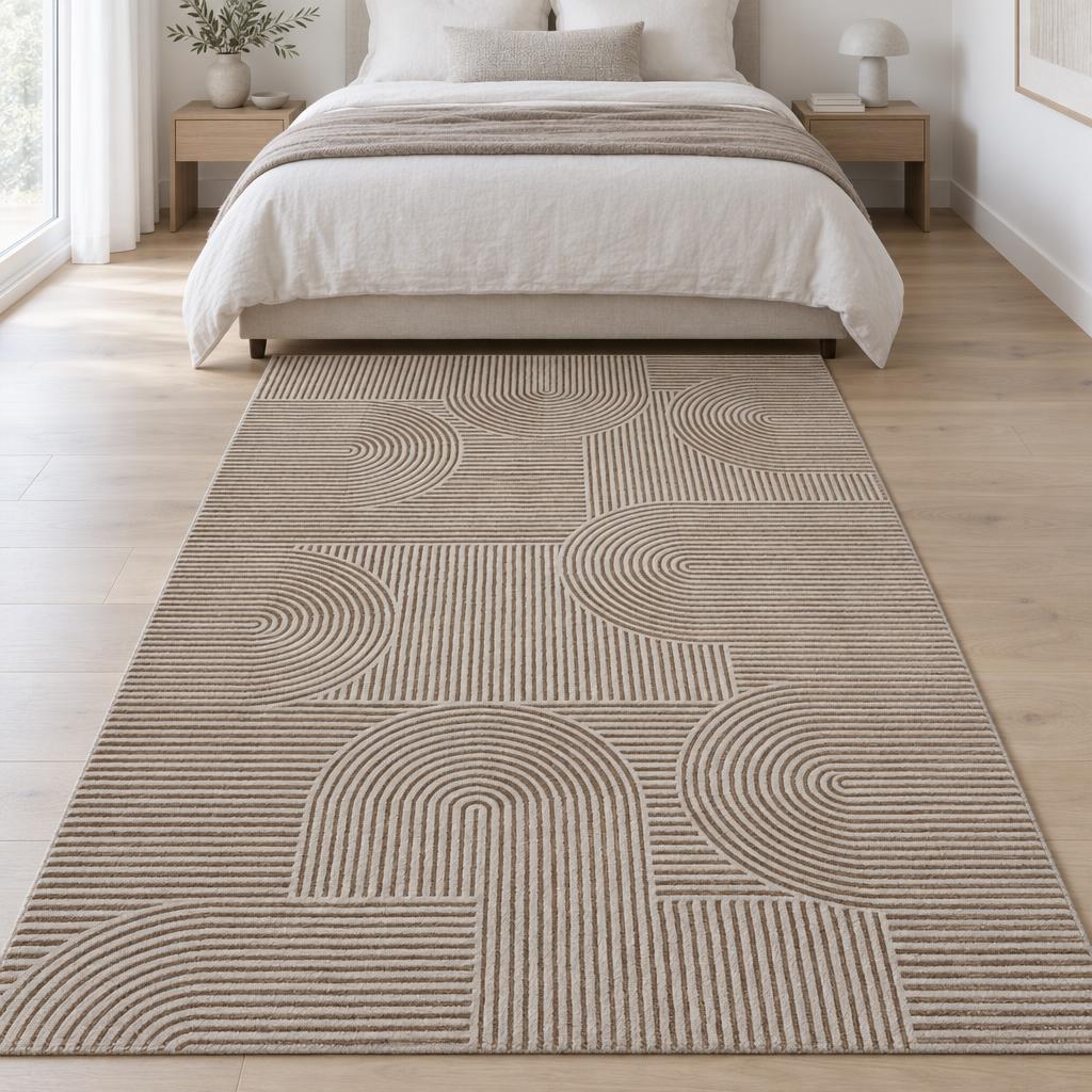 Vloerkleed Studio Beige met bogen en lijnen in reliëf aan het voeteneind van een tweepersoonsbed